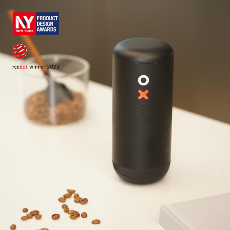 Grinding OX Pro on a table, with New York Product Design Awards and Red Dot 2023 marks